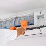 man-cleaning-air-conditioner-dirty-filter-min.jpg